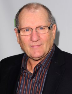 Ed O’Neill in a black jacket with a shirt with stripes