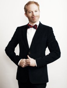 Jesse Tyler Ferguson body picture in a black suit and wearing a red bow tie