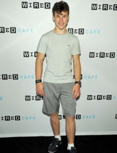 Nolan Gould looking great in a casual outfit: grey shorts and beige shirt