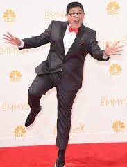 Rico Rodriguez in a black suit and bow tie in a funny position during an award cerimony